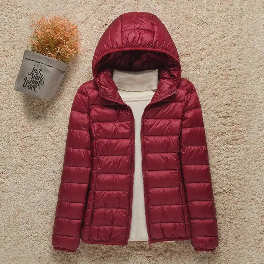 Essential women's travel jacket: lightweight, hooded, quilted, and packable puffer for all seasons.