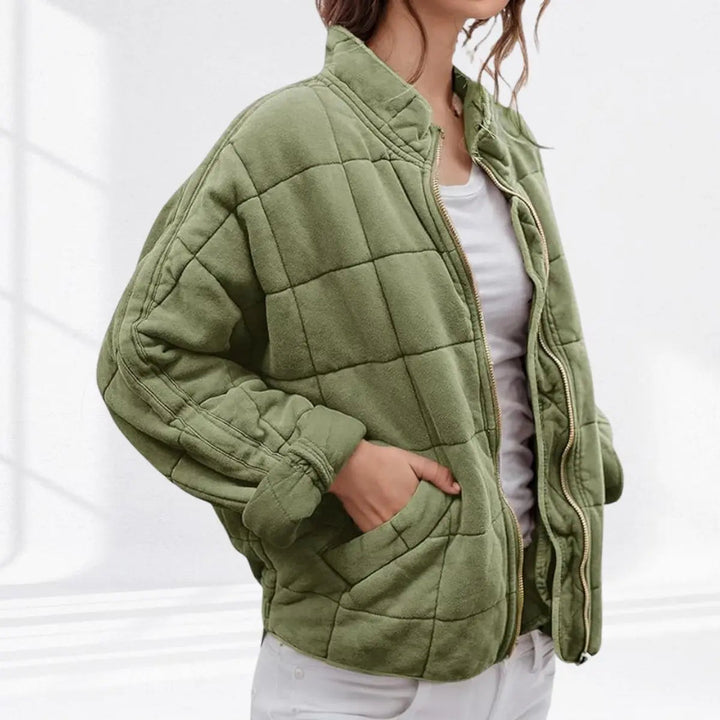 Close-up of a women's lightweight quilted jacket, zip-up, with a defined stand collar. Padded for warmth & style.