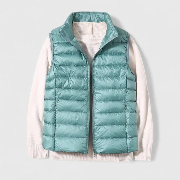 Zip-up women's sleeveless gilet. Lightweight quilted puffer vest with a high stand collar for extra warmth.