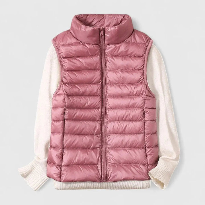 Chic women's sleeveless puffer gilet with stand collar and full zip. Ideal lightweight outerwear for casual style.