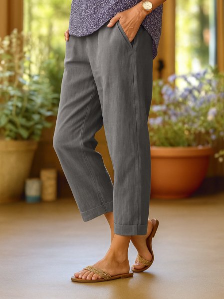 Tapered cropped linen trousers for women with cuffed hem, ideal for smart casual summer fashion.
