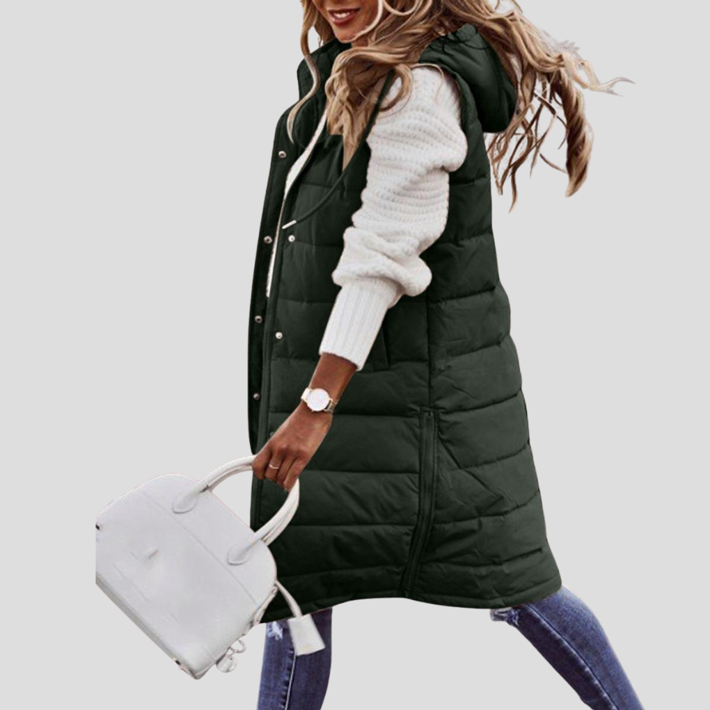 Padded women's long hooded bodywarmer. Stylish, warm sleeveless jacket for winter wear & casual comfort.