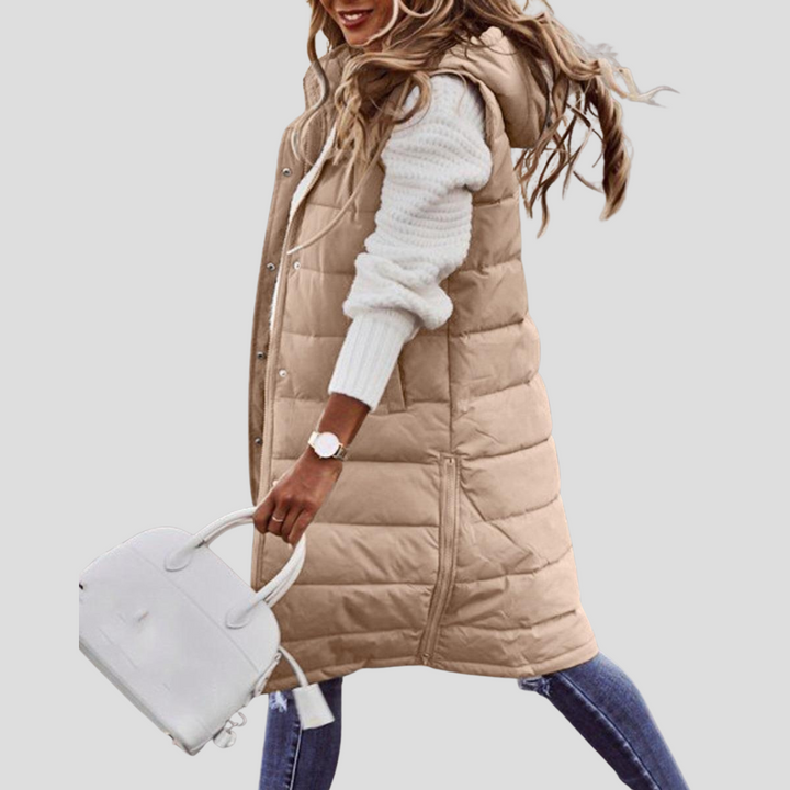 Versatile women's long hooded bodywarmer, ideal for layering outfits. Essential fall & winter fashion outerwear.
