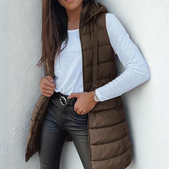 Women's sleeveless long puffer vest with hood, lightweight and warm, a chic casual piece for fall & winter outfits.