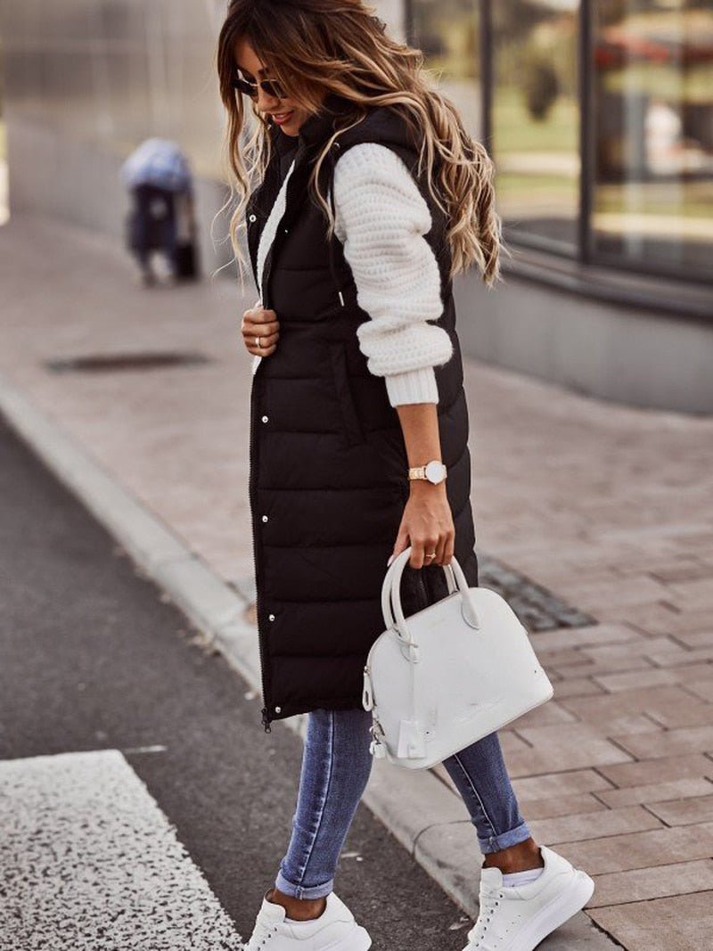 Quilted long puffer vest for women, featuring a cozy hood & practical pockets, perfect for fall/winter.