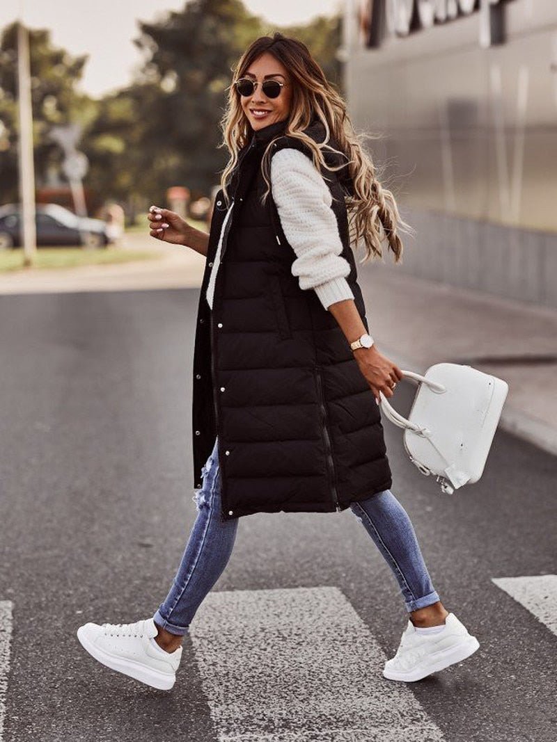 Elegant women's long hooded puffer vest, ideal for stylish layering over sweaters and winter outfits.