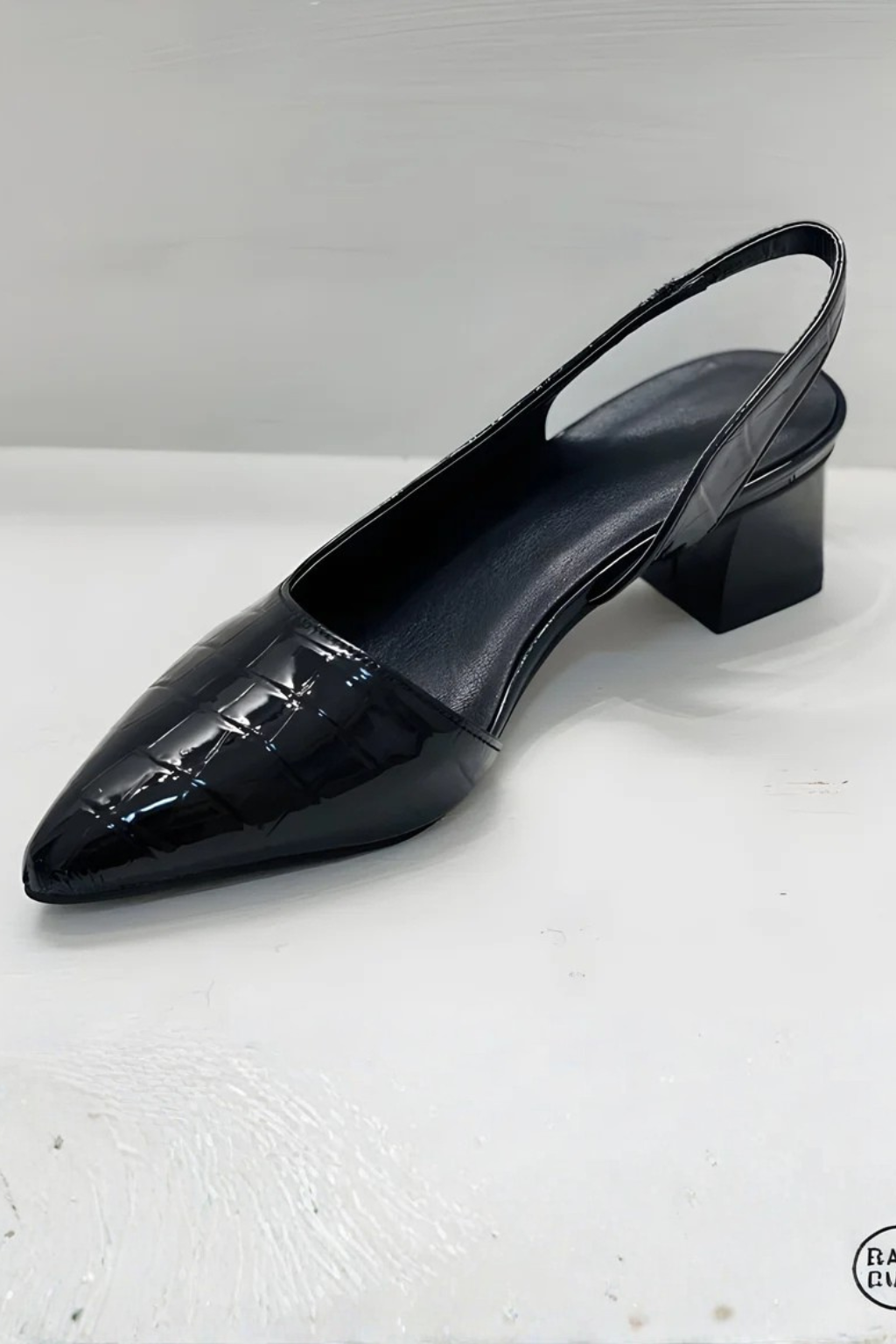 Black low heel slingback pumps with a pointed toe. Chic women's fashion shoes for elegant occasions.