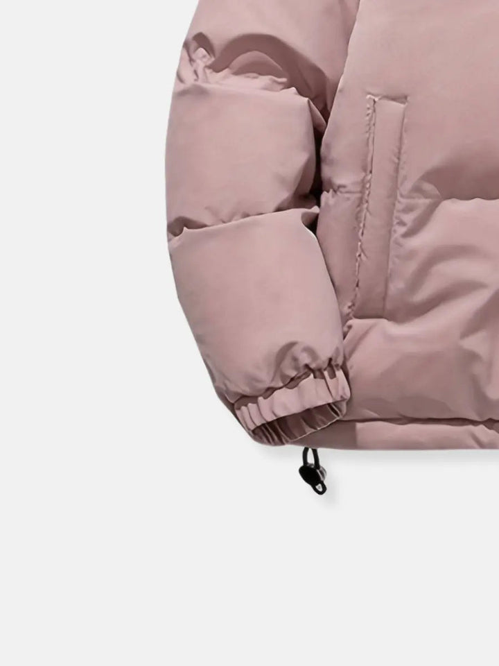 Modern women's puffer coat, chic for travel and cold weather, with a cozy hood.