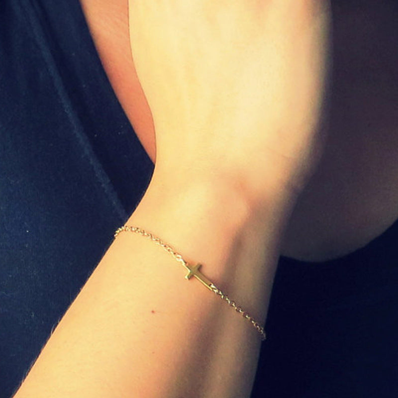 Women's minimalist silver cross charm bracelet, elegant faith jewelry with adjustable chain.