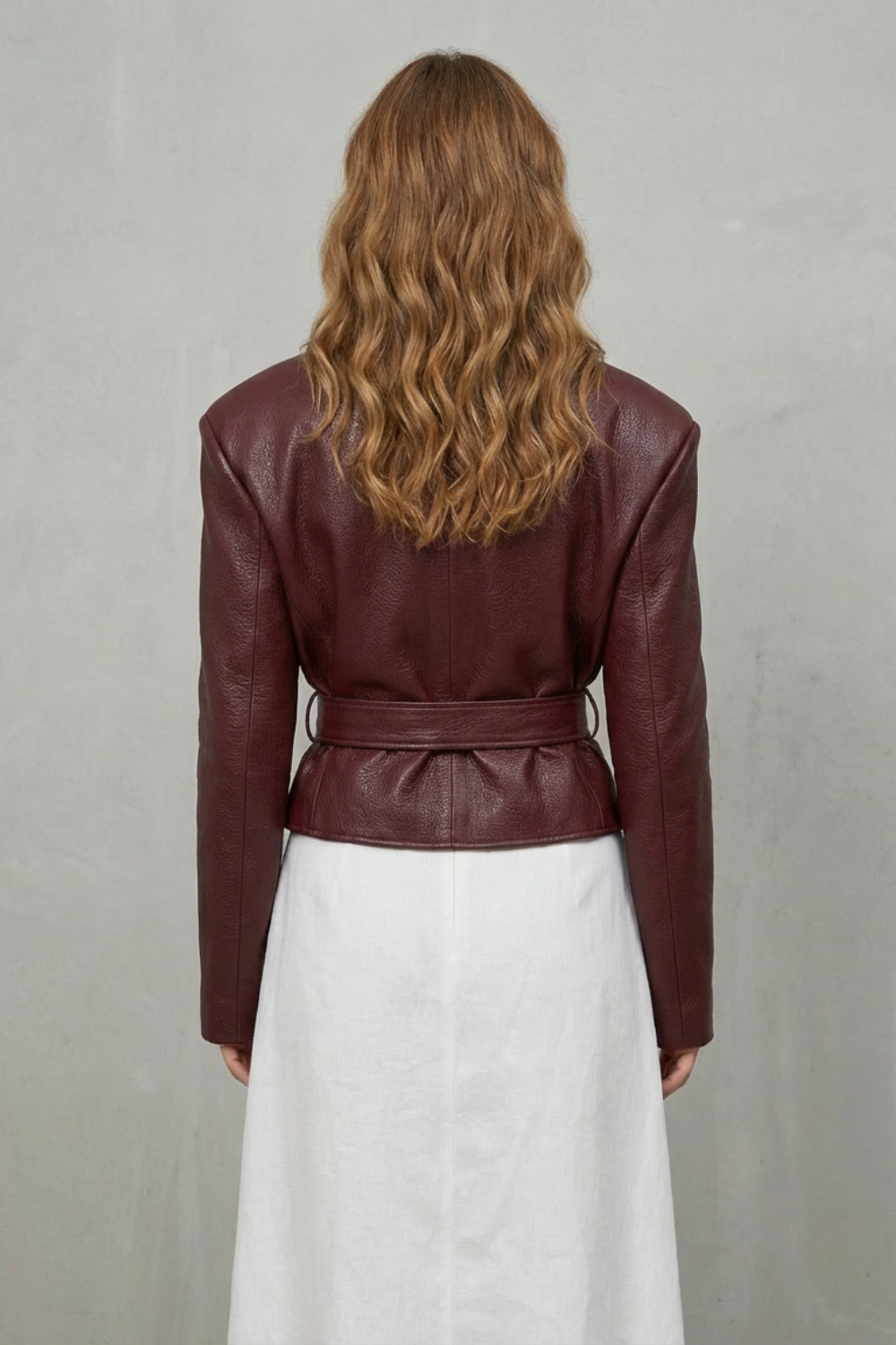Back view of a modern sculpted women's jacket, showcasing sleek design and tailored elegance.