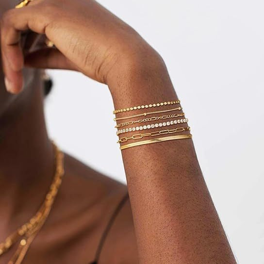Elegant women's layered charm bracelets, combining delicate silver and shimmering gold, ideal gift.