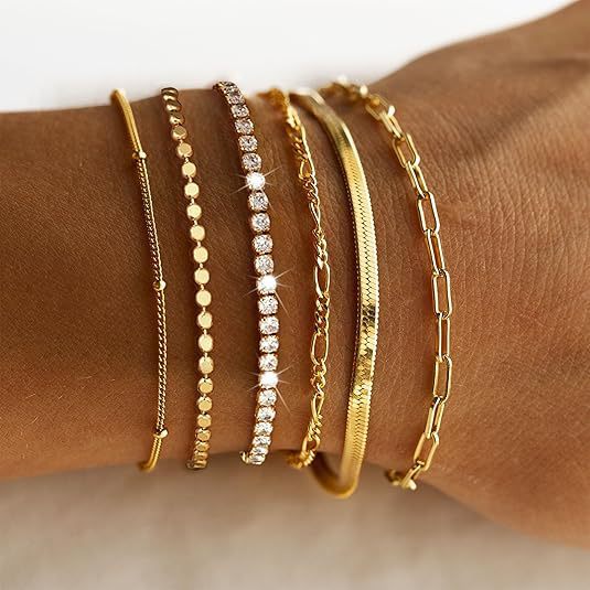 Delicate multi-layered women's charm bracelet set, blending silver and gold for a sophisticated look.