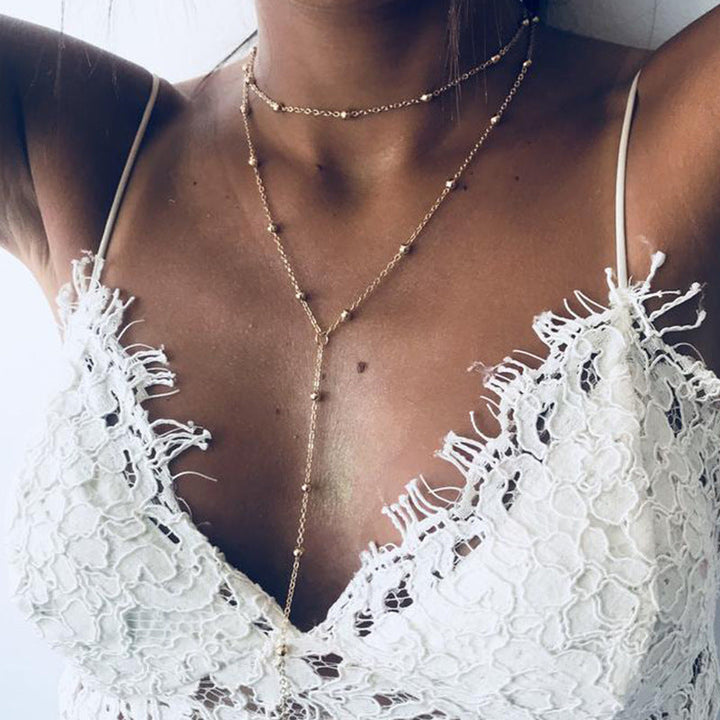 Elegant gold multi-layer lariat necklace for women, featuring a delicate charm. Perfect fashion statement jewelry.