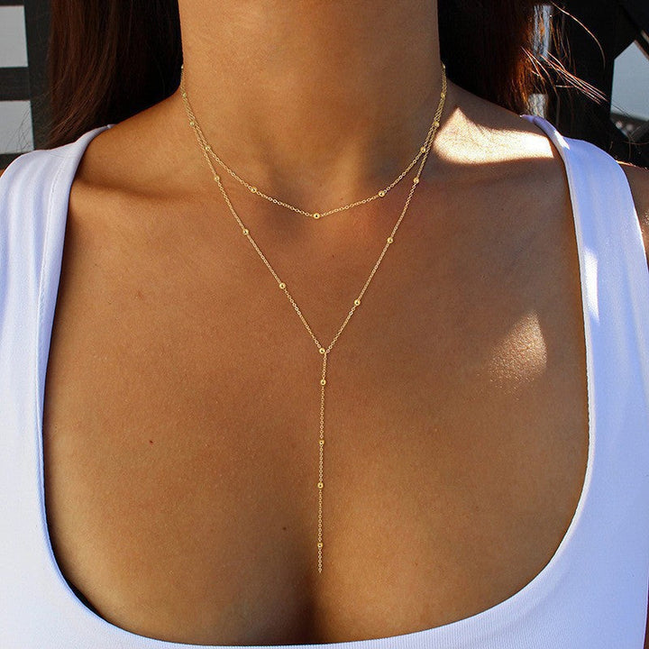 Delicate multi-layered gold lariat necklace with a charming pendant for women. Stylish jewelry accessory.