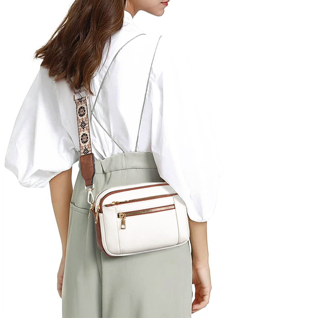 Practical women's multi-zip crossbody bag, ideal for travel with secure compartments and a fashionable printed strap.