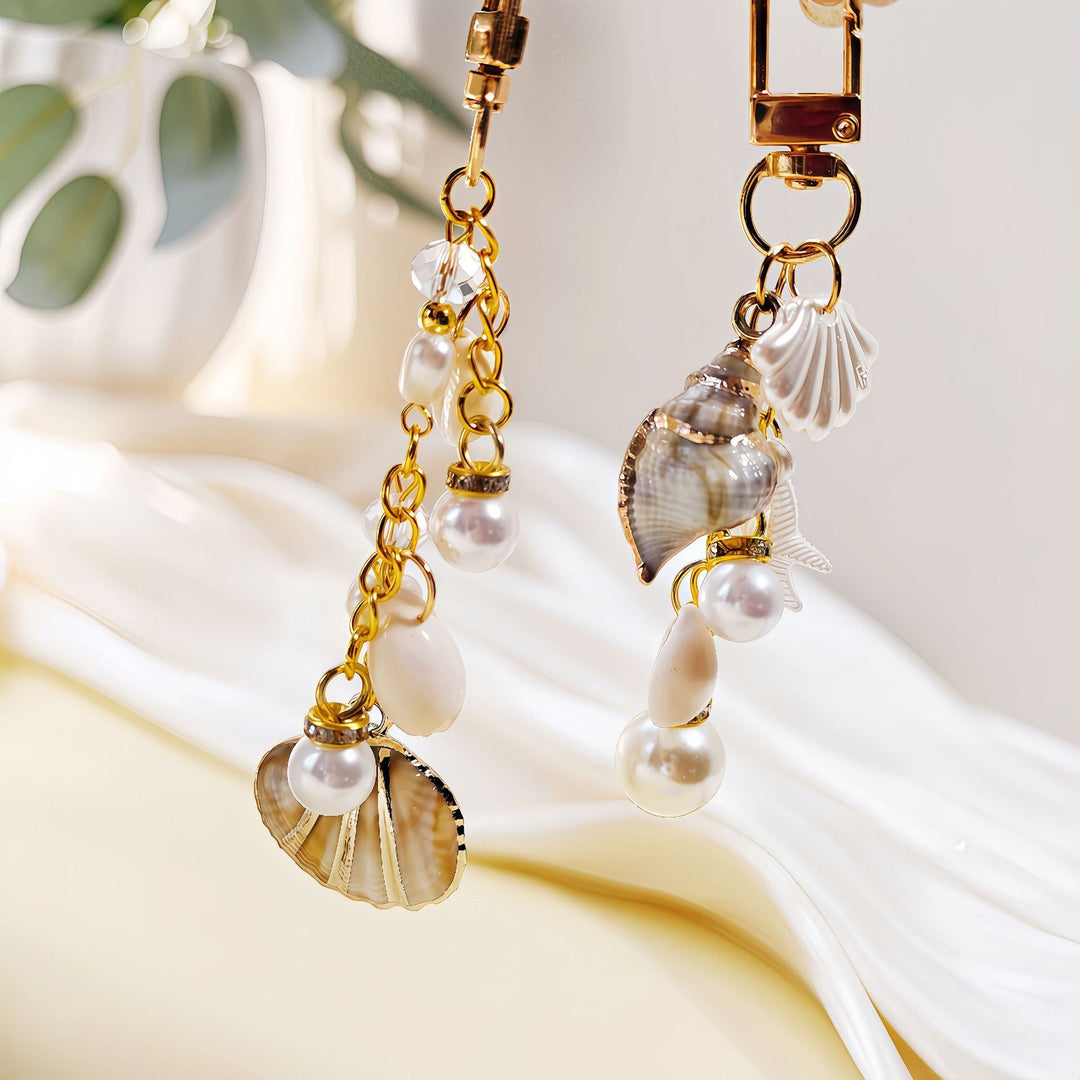 Stylish nautical women's keychain, ideal for bags or keys, featuring ocean-inspired shell, starfish, and pearl.