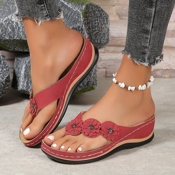 Women's wedge heel orthopedic sandals, featuring flower detail, arch support, and slip-on ease.
