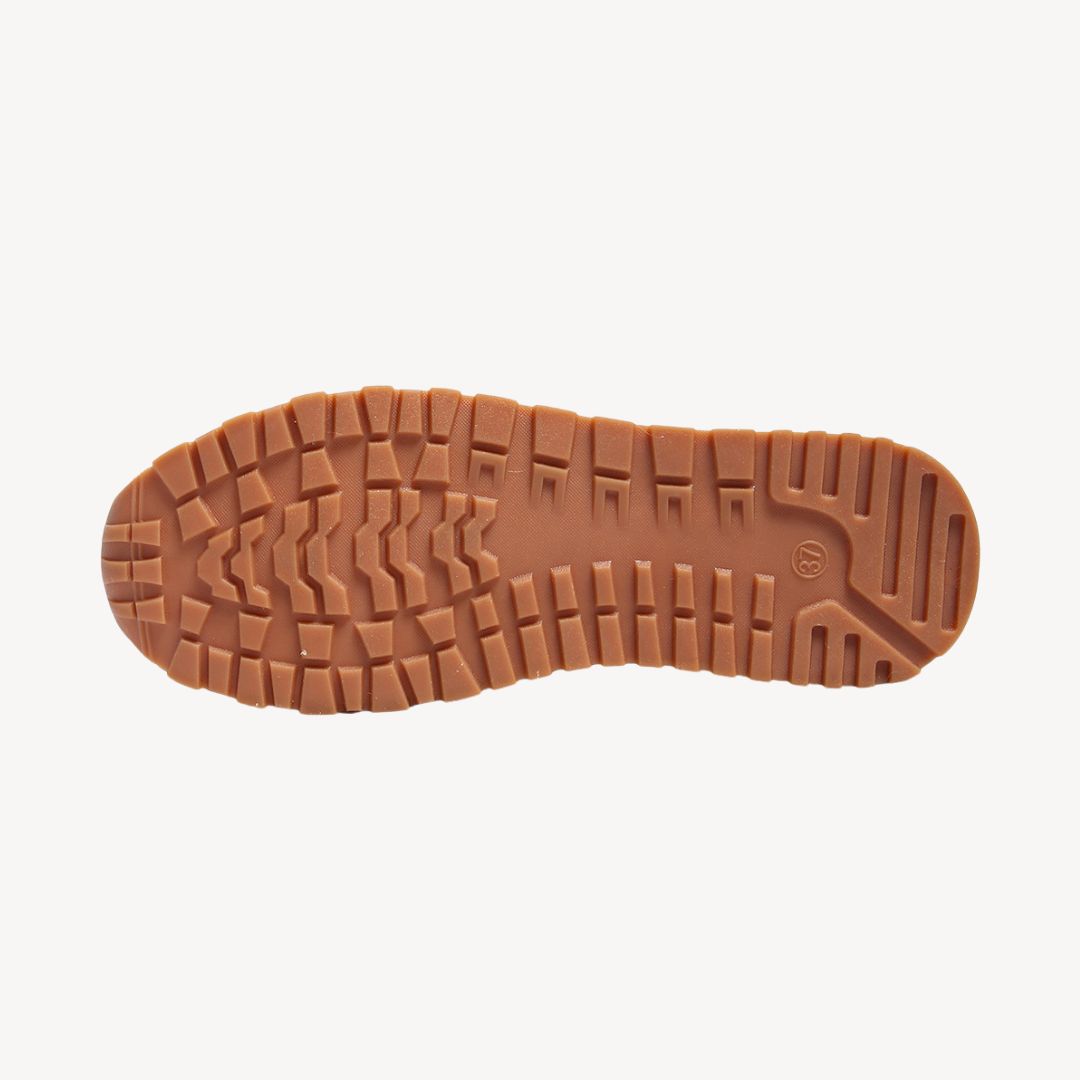 Close-up of a women's orthopedic loafer, highlighting the fashionable gold chain accent on top.