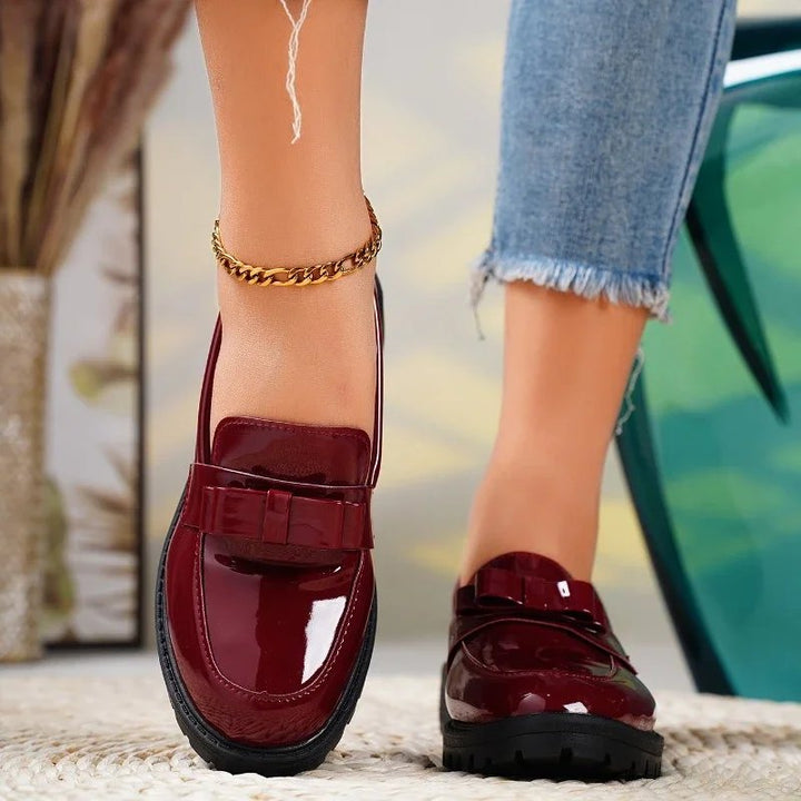 Elegant women's patent leather loafers with delicate bow detail. Comfortable orthopedic slip-on shoes, versatile style.