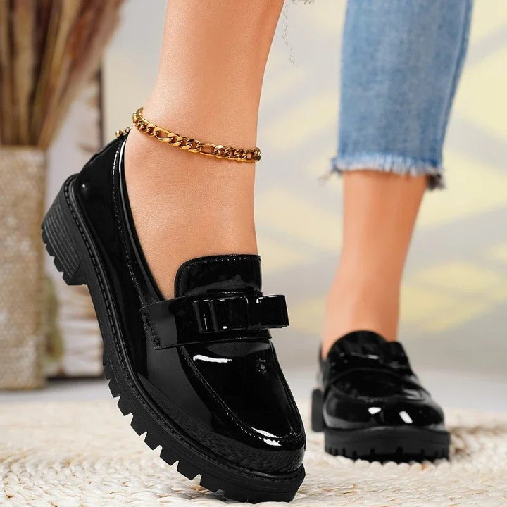 Chic women's orthopedic patent leather loafers. Slip-on comfort shoes with a distinctive bow & durable chunky sole.