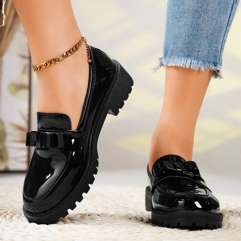 Fashionable women's orthopedic loafers in shiny patent leather. Easy slip-on style with an elegant front bow.