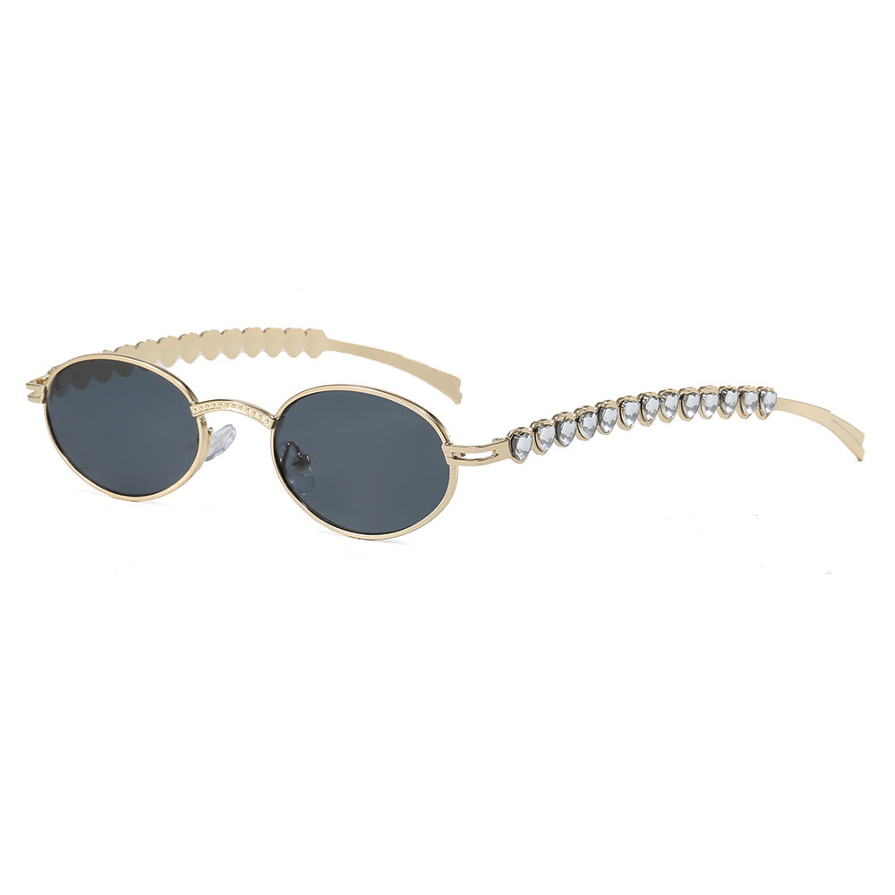 Close-up of luxury oval frame women's sunglasses, showcasing opulent detailing and glare-reducing lenses.