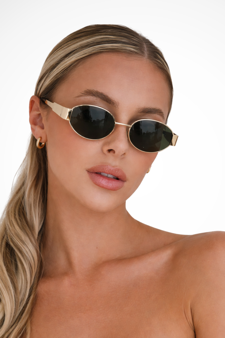 Women's oval metal frame sunglasses with tinted lenses for stylish UV protection.