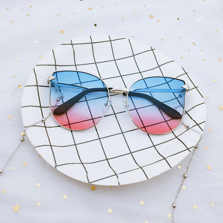 Bold oversized cat-eye sunglasses for women, modern chic design, fashion-forward UV protective eyewear.