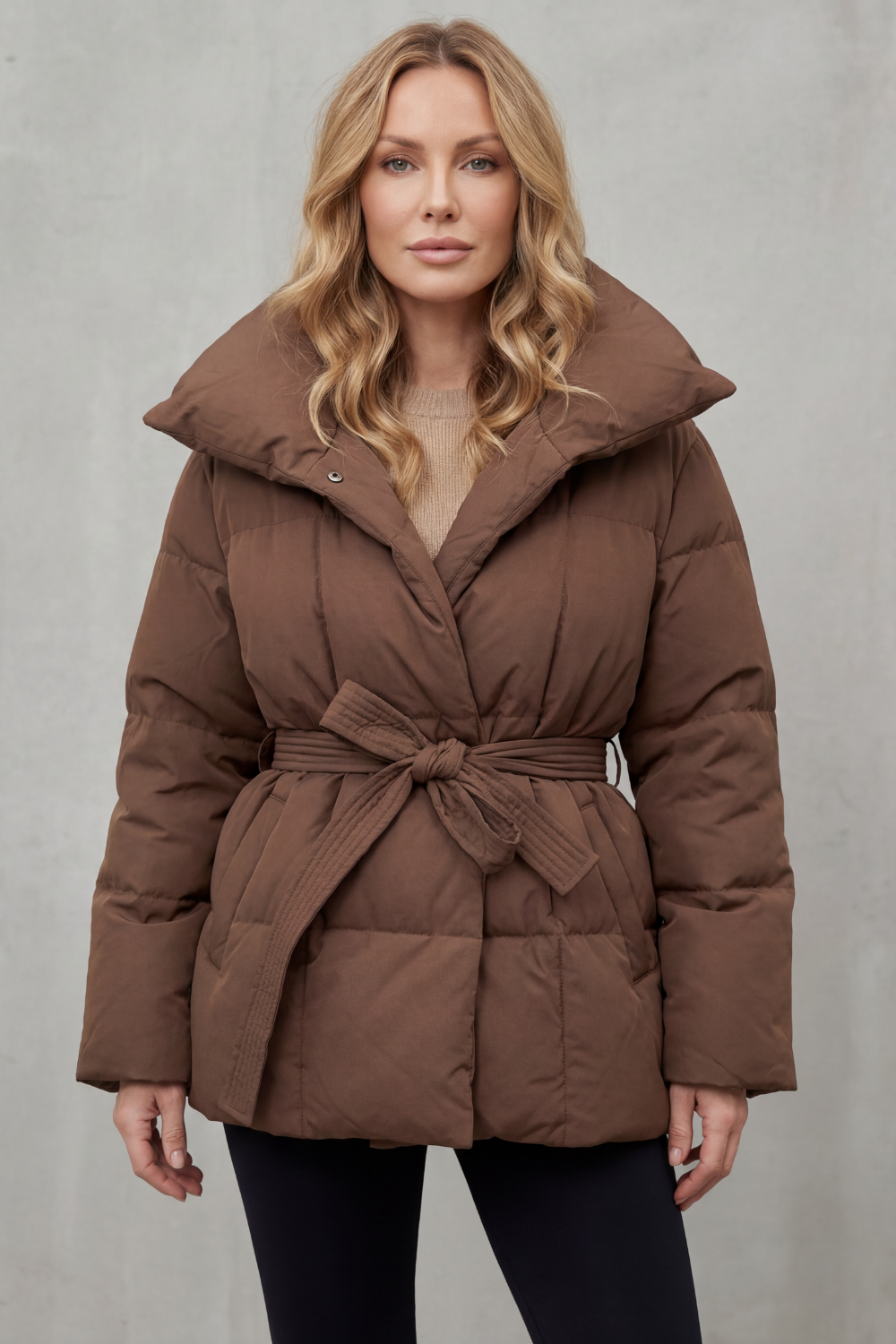 Chic women's long puffer coat with an elegant oversized collar and flattering belt, ideal for winter fashion.
