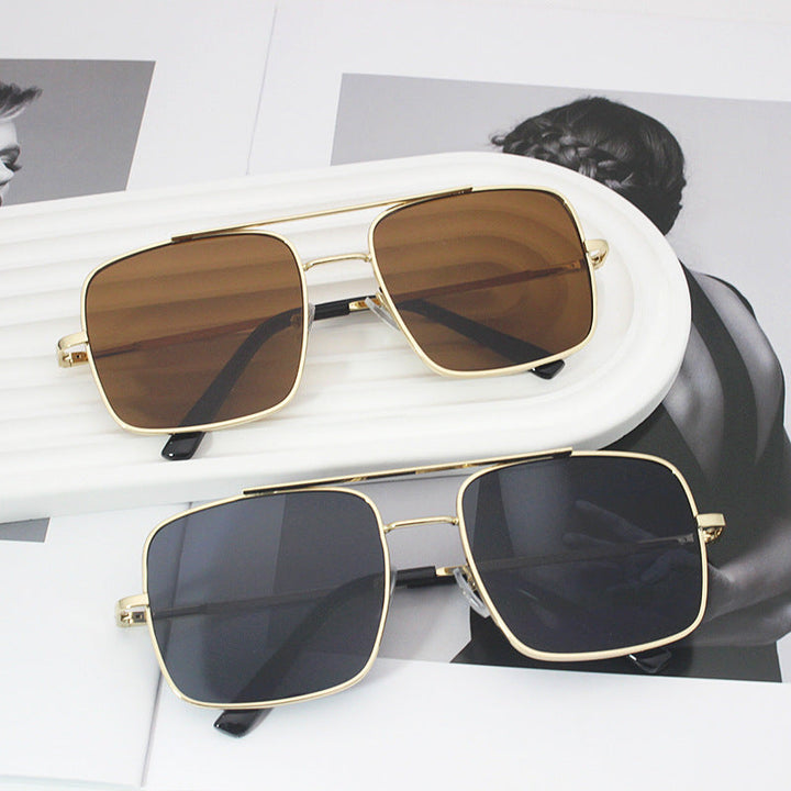 Women's oversized square sunglasses with golden frame, offering stylish UV protection.
