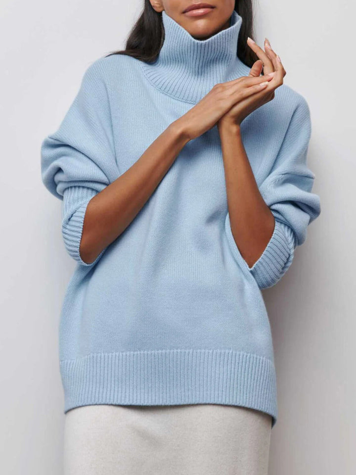 Women's oversized turtleneck sweater with chic elbow slits, perfect for cozy fall and winter fashion.