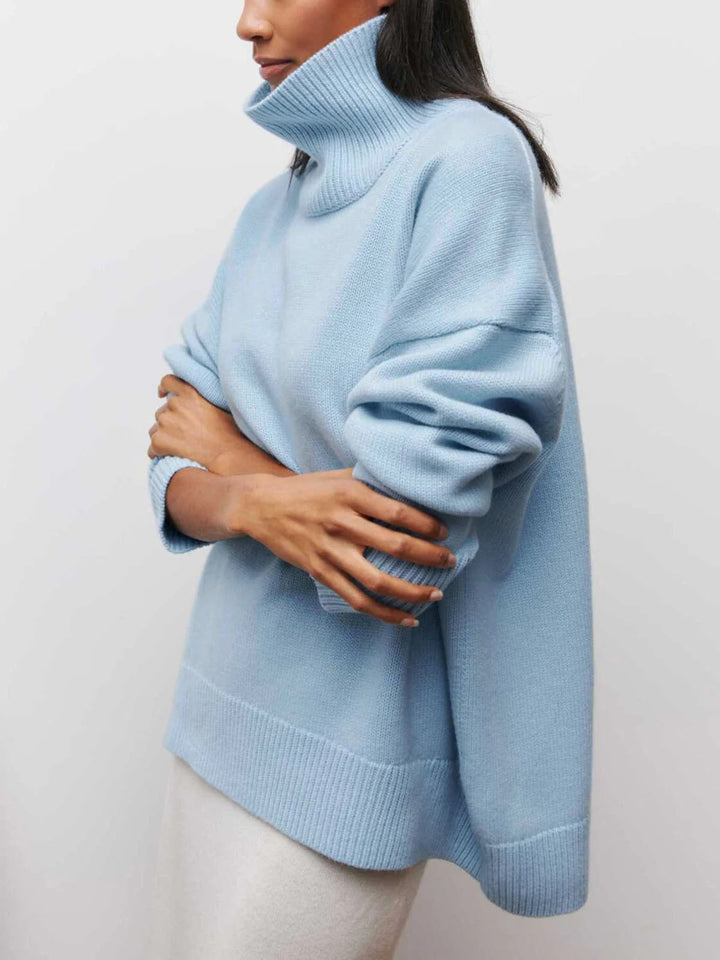 Relaxed fit women's oversized turtleneck pullover sweater, featuring trendy elbow slits for chic comfort.