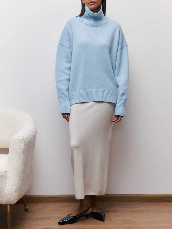 Soft, cozy knit oversized women's turtleneck pullover sweater, with modern elbow slits for everyday wear.