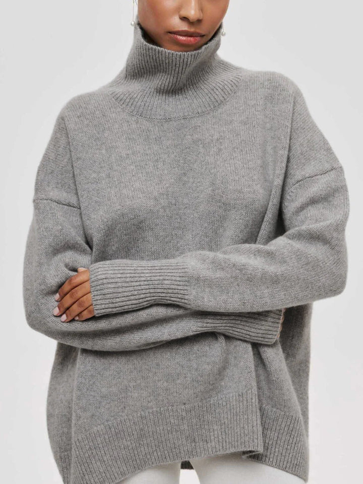 Close-up of trendy elbow slits on a soft, cozy oversized women's turtleneck sweater, a fall fashion must-have.