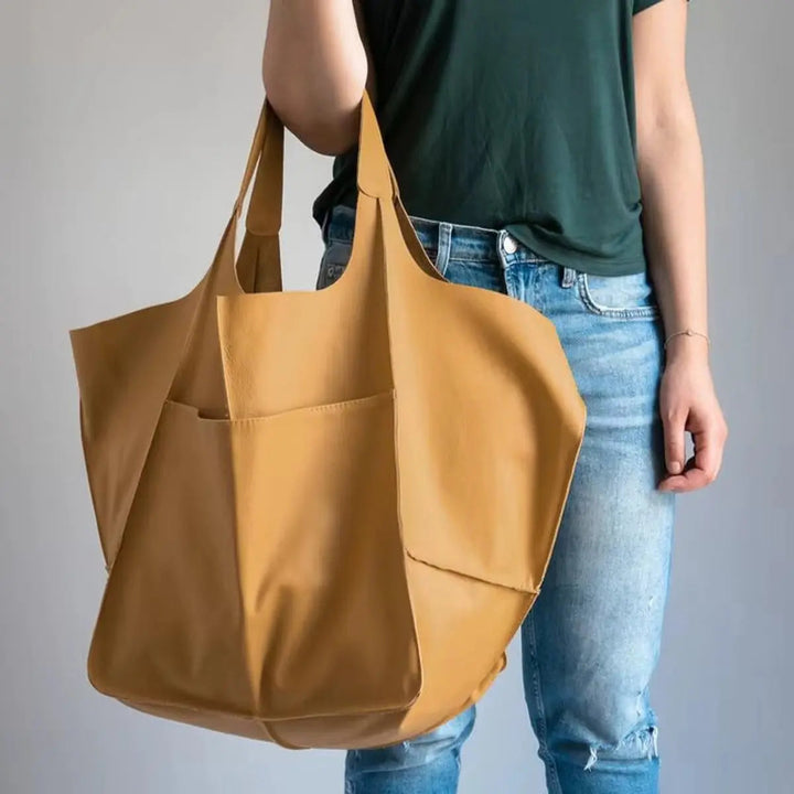 Modern women's oversized vegan leather magnetic tote bag, a sophisticated work & fashion accessory.