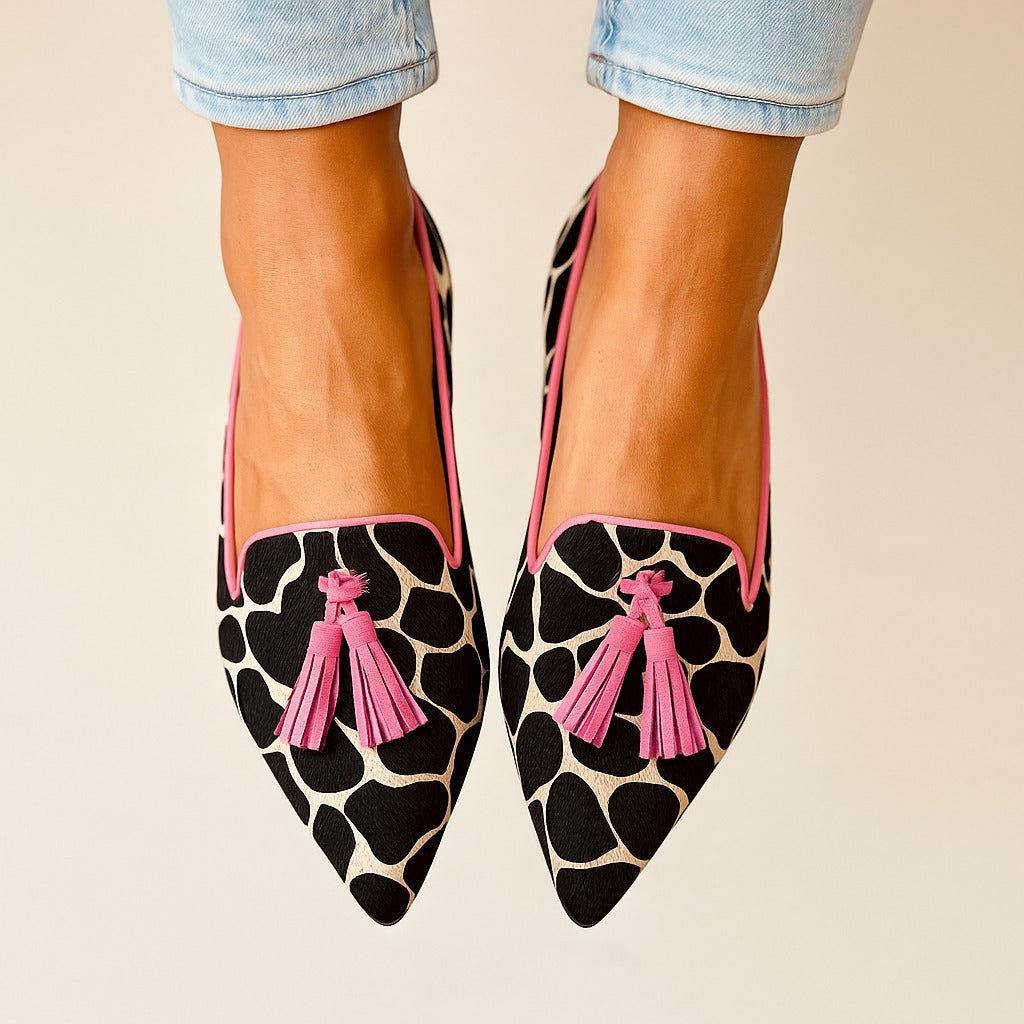 Close-up: Stylish women's patterned loafers with decorative tassels. Comfortable slip-on flat shoes.