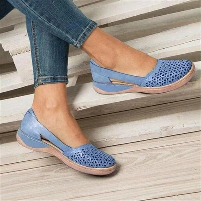 Easy slip-on women's perforated round toe wedge sandals. Featuring chic cutouts for effortless style.