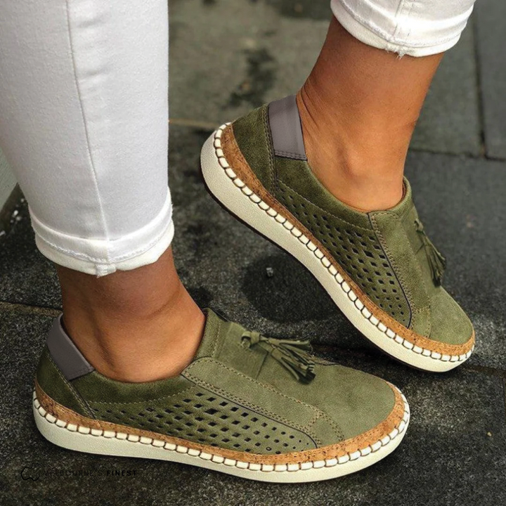 Women's perforated slip-on flats with chic tassels. Comfortable vegan leather footwear for everyday style.