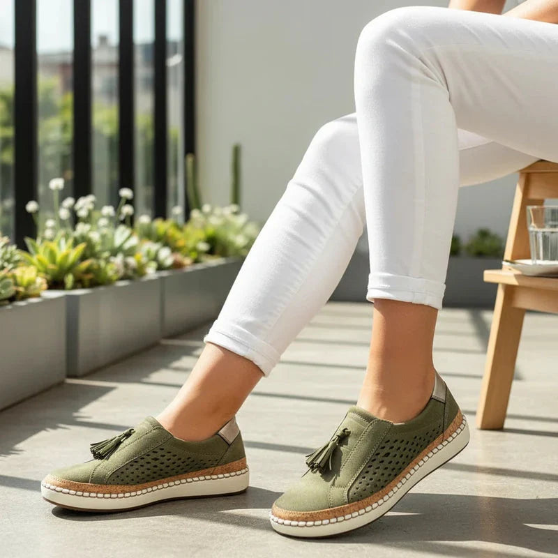 Stylish women's perforated vegan leather slip-on flat shoes with decorative tassels for spring comfort.