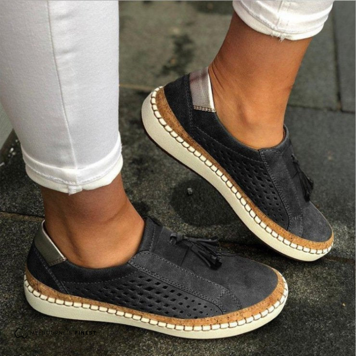 Chic perforated slip-on flats for women. Comfortable vegan leather shoes with tassels, ideal for spring.