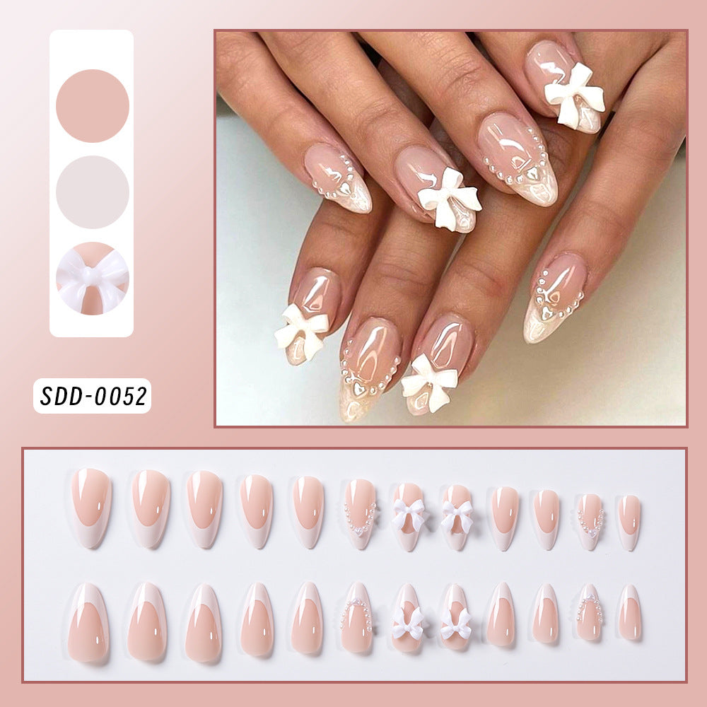 Decorative fake nails for women, adorned with cute bows, offering a fashionable and quick home manicure solution.