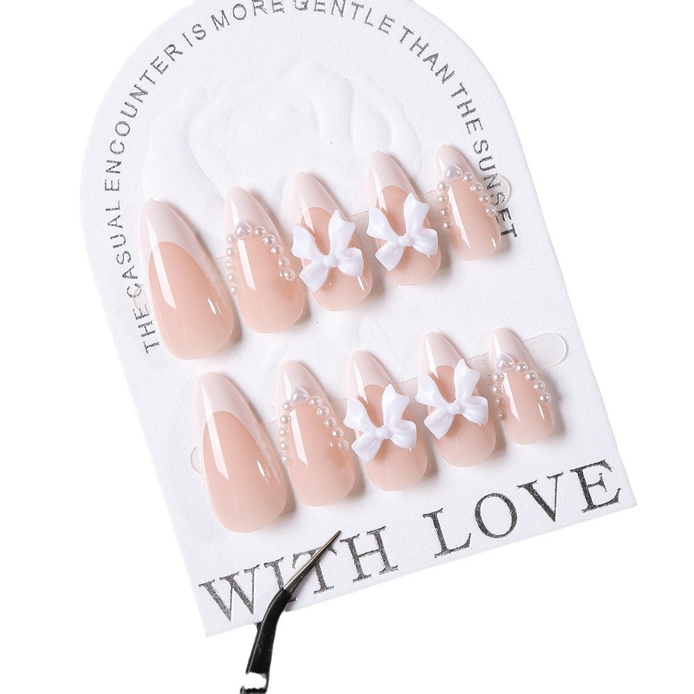 Stylish press-on nail tips for women with intricate bow and gem designs, ideal for a beautiful at-home manicure.