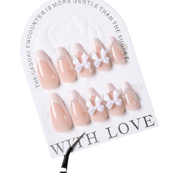 Stylish press-on nail tips for women with intricate bow and gem designs, ideal for a beautiful at-home manicure.