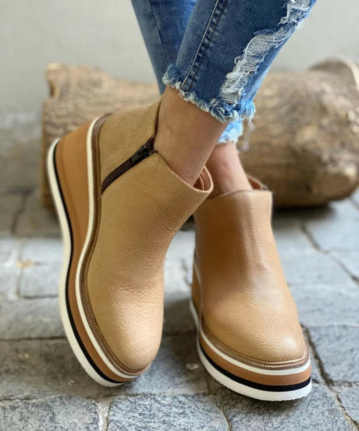 Fashionable women's zip-up platform wedge ankle boots with a sleek design and comfortable chunky sole.