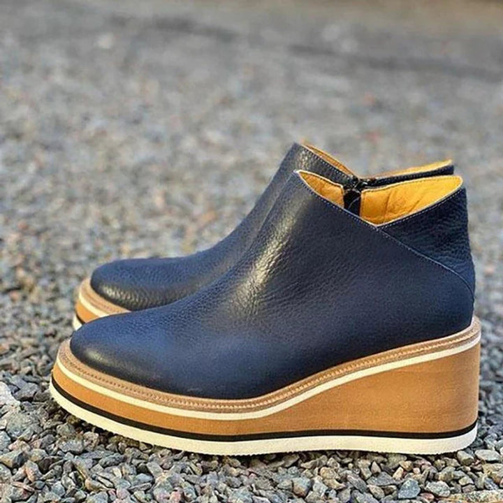 Close-up of women's platform wedge ankle boots, highlighting the side zip closure and robust chunky sole.