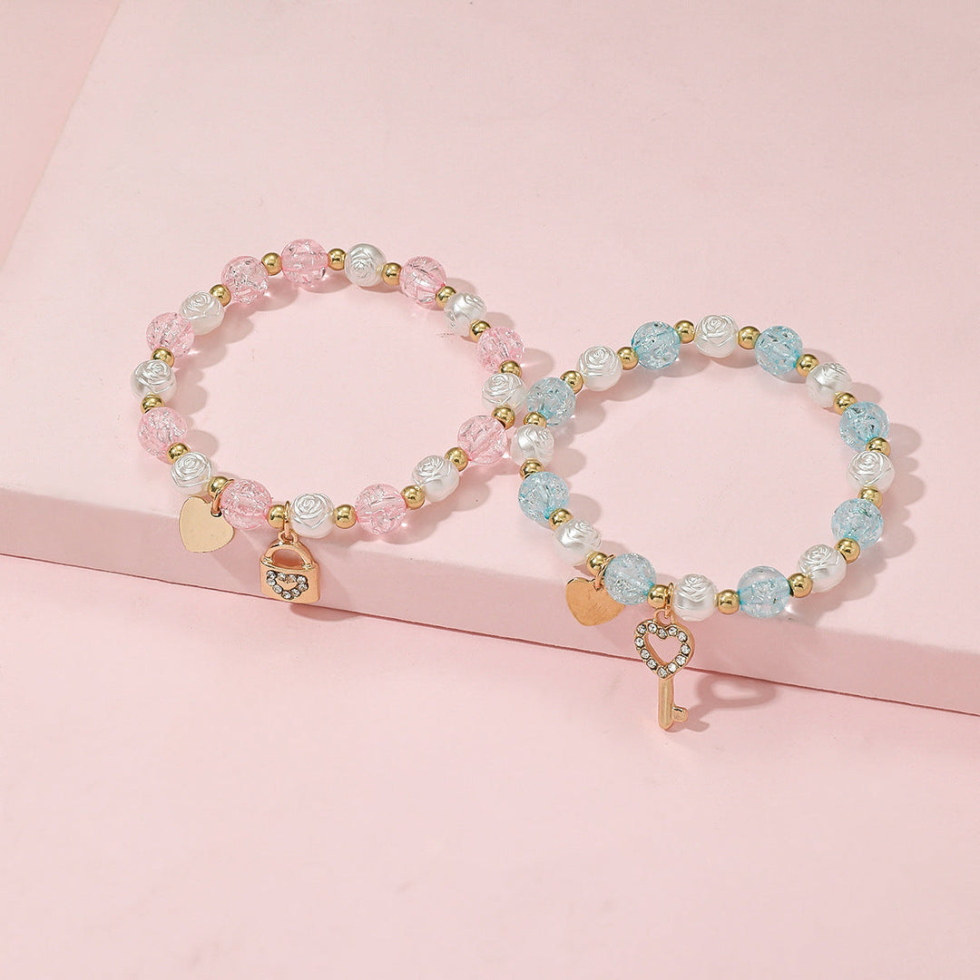Stackable women's pastel beaded bracelet set with unique heart & key charms. Versatile fashion accessory.