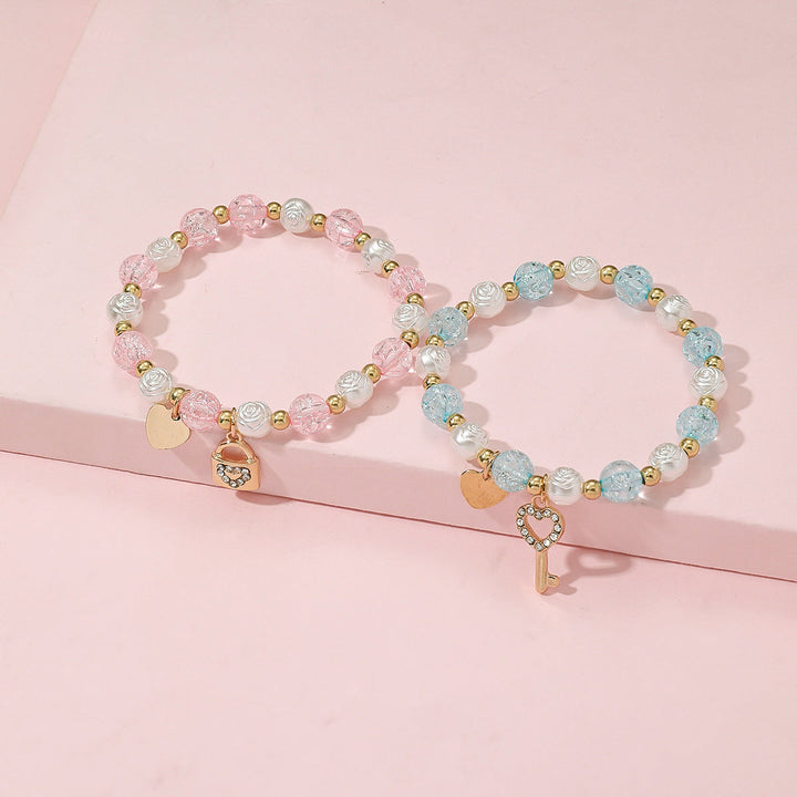 Stackable women's pastel beaded bracelet set with unique heart & key charms. Versatile fashion accessory.