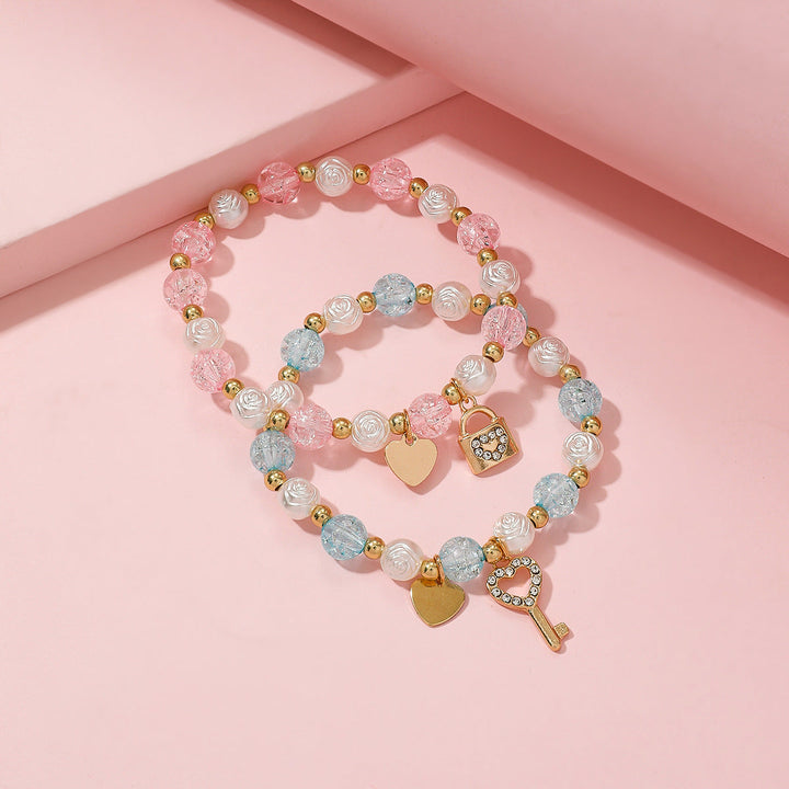 Chic women's charm bracelet set, ideal for everyday wear or as a gift. Features heart & key charms on pastel beads.