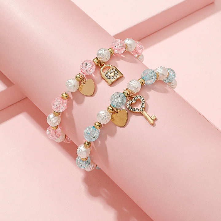 Detailed view of a women's pastel beaded bracelet set, showcasing the intricate heart & key charm designs.