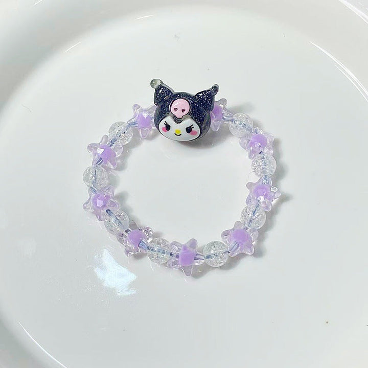 Close-up of a charming women's bracelet with star and face pendants, ideal for a playful look.